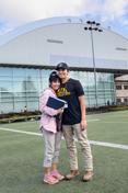 A mother and son stand on the practice field of the ASUI-Kibbie Activity Center.